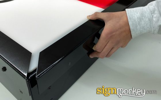 Face retainer on an illuminated sign cabinet