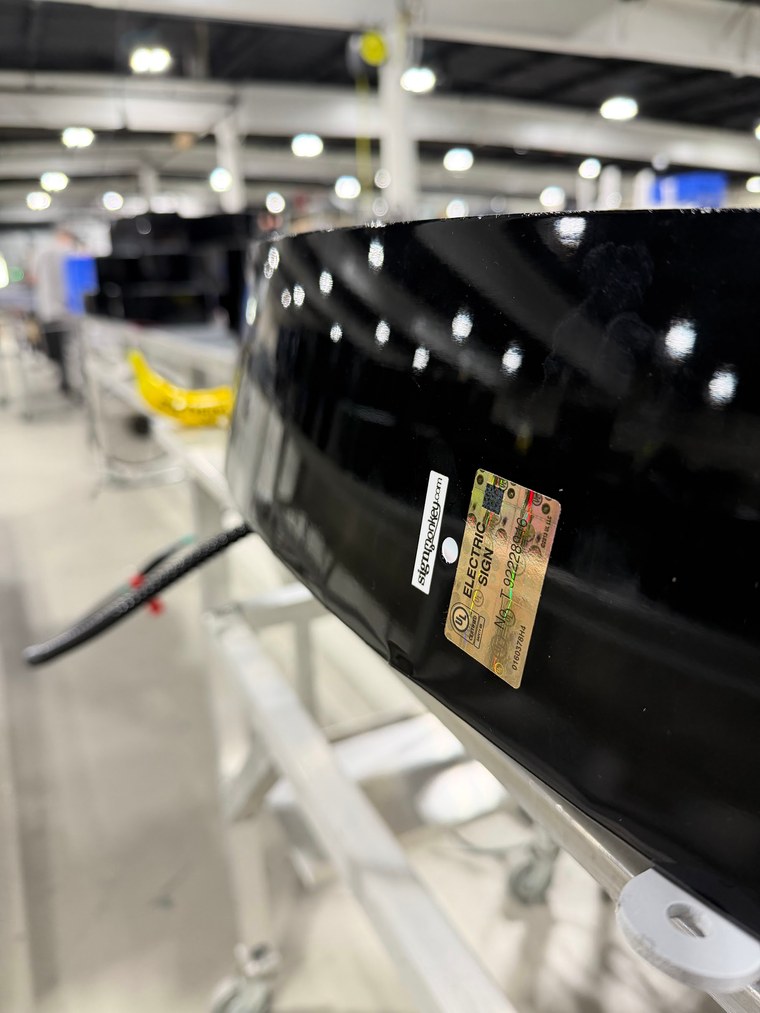 UL certified electric sign label on a black SignMonkey sign in the shop